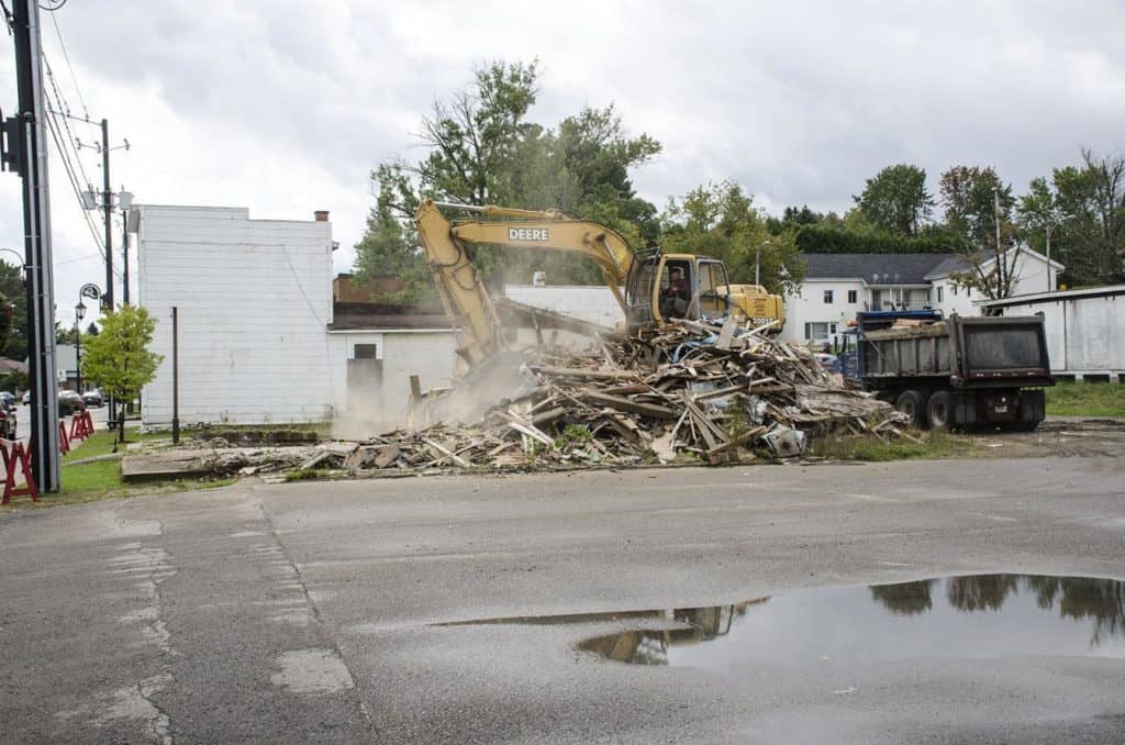 Trois vieux bâtiments mordent la poussière