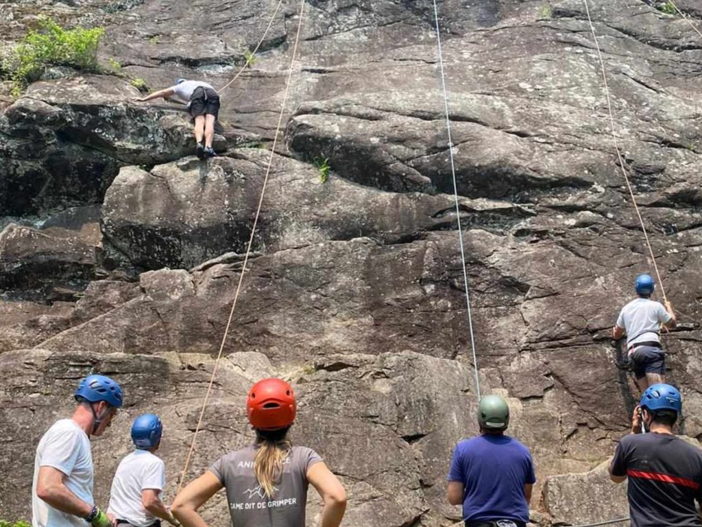 Ges gens au sol assurent la sécurité des grimpeurs sur une paroi rocheuse
